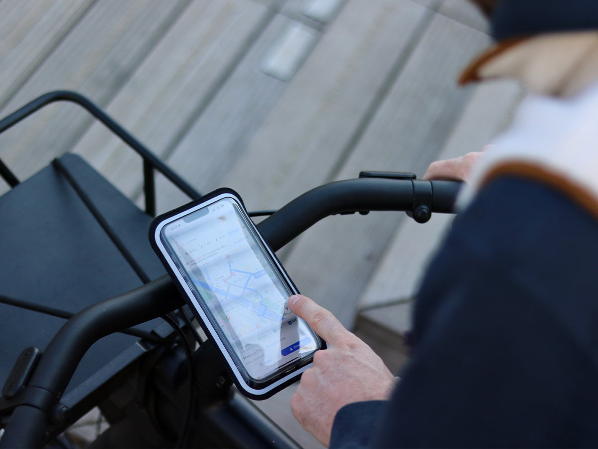 Vista del smartphone montado en el manillar de la bicicleta, en su funda magnética, perfectamente táctil. Ideal para la navegación urbana.