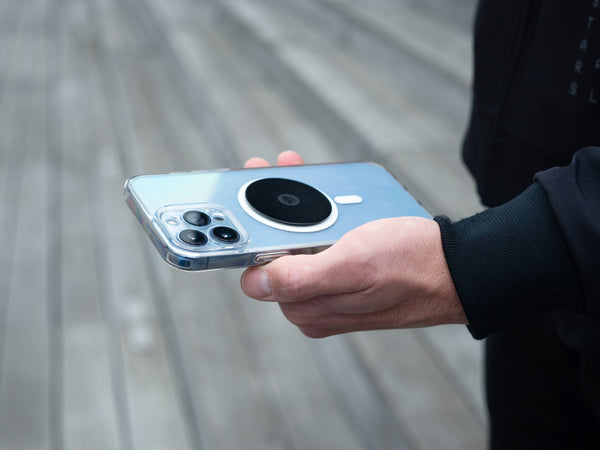 Smartphone con placa metálica Shapeheart en la mano, ideal para fijar el teléfono de forma segura al soporte Shapeheart.